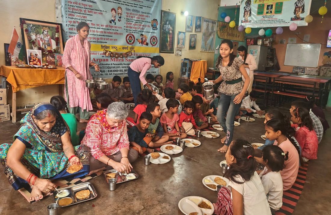 Volunteers serving a meal to children at the learning centre