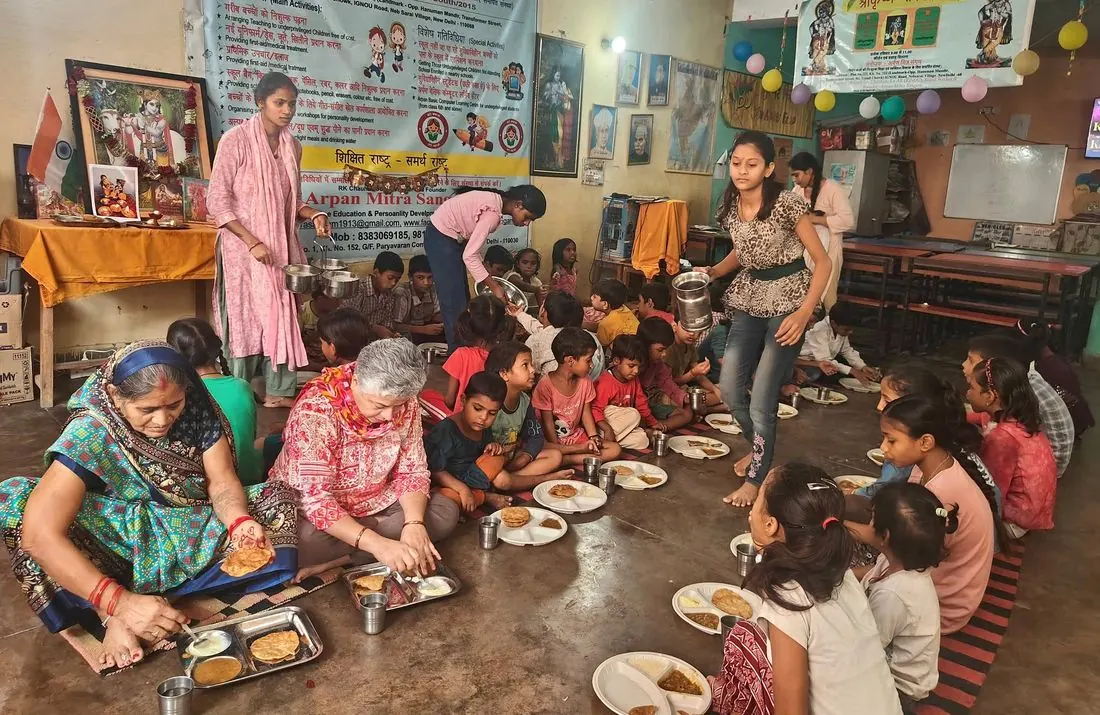 Volunteers serving a meal to children at the learning centre