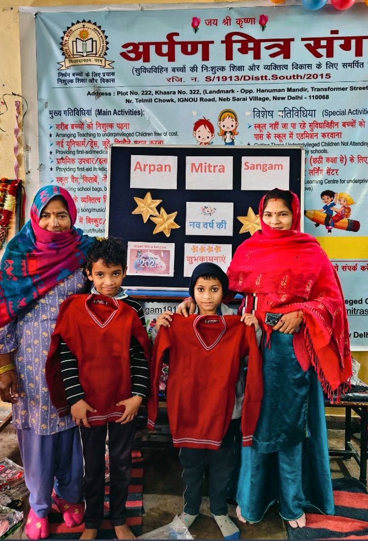 Two children holding their new school sweaters with volunteers